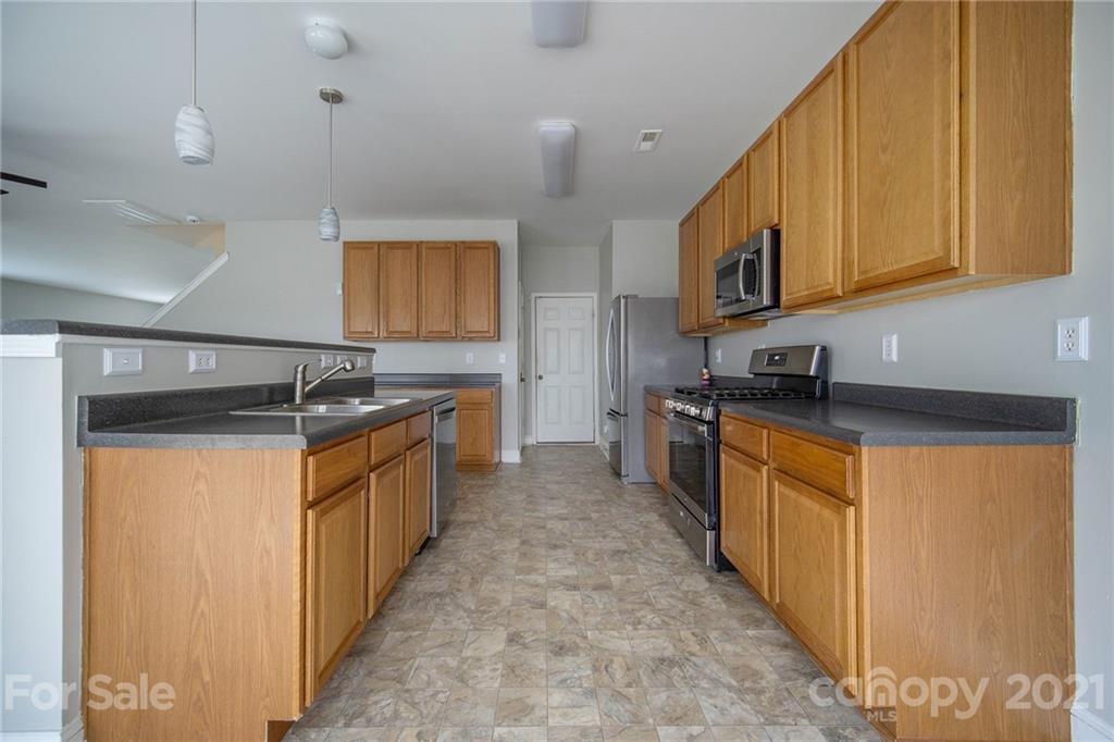 382 Primrose Walk Fort Mill, SC 29715 - Photo 11 of 20 a kitchen with stainless steel appliances granite countertop a refrigerator and a stove top oven