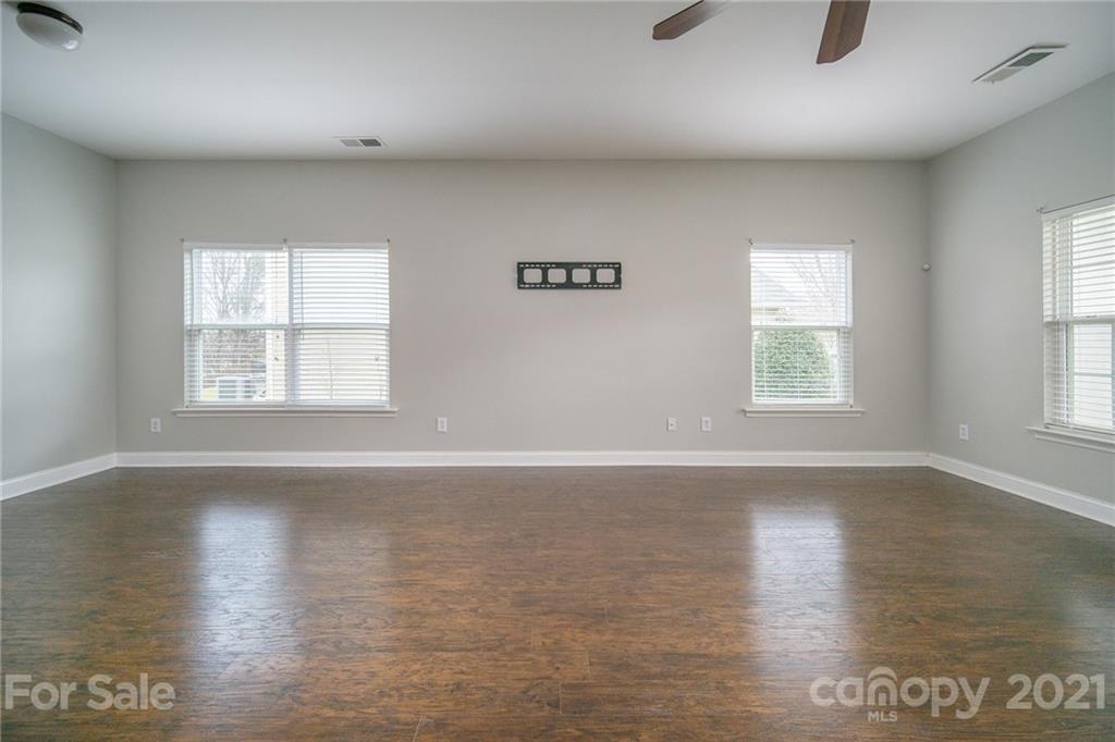 382 Primrose Walk Fort Mill, SC 29715 - Photo 7 of 20 an empty room with wooden floor and windows
