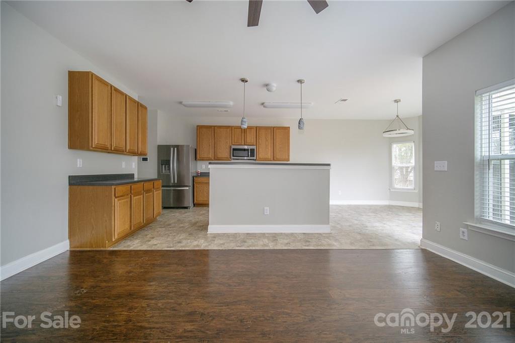 382 Primrose Walk Fort Mill, SC 29715 - Photo 9 of 20 a view of a kitchen with kitchen island a sink wooden floor and counter space