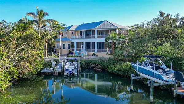 a view of a house with a yard and a pond