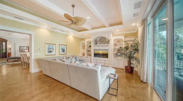 a living room with furniture a flat screen tv and a floor to ceiling window