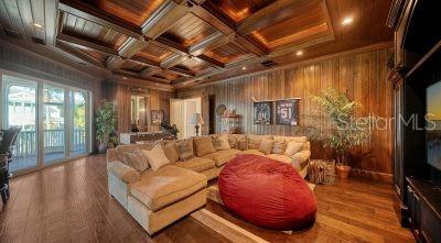 5309 Hidden Harbor Road Sarasota, FL 34242 - Photo 53 of 88 a living room with furniture a flat screen tv and a floor to ceiling window