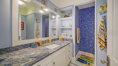 5309 Hidden Harbor Road Sarasota, FL 34242 - Photo 71 of 88 a bathroom with a granite countertop sink and a mirror