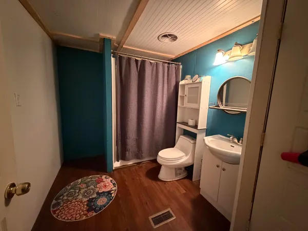 a bathroom with a toilet a sink and a mirror