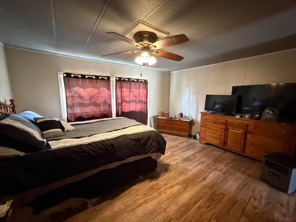 a bedroom with a bed window and a flat screen tv
