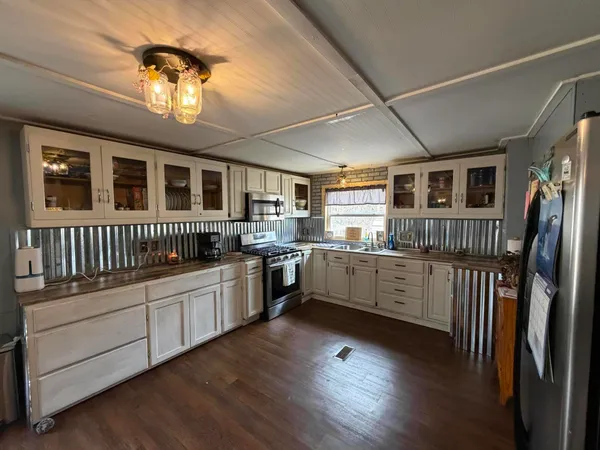 a kitchen with stainless steel appliances granite countertop a stove and cabinets