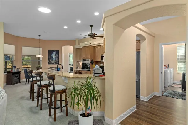 a kitchen with furniture a counter top space a sink a window and stainless steel appliances