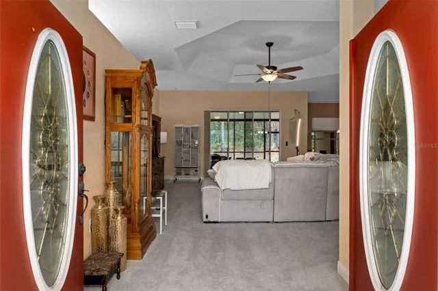 a living room with furniture kitchen view and a chandelier