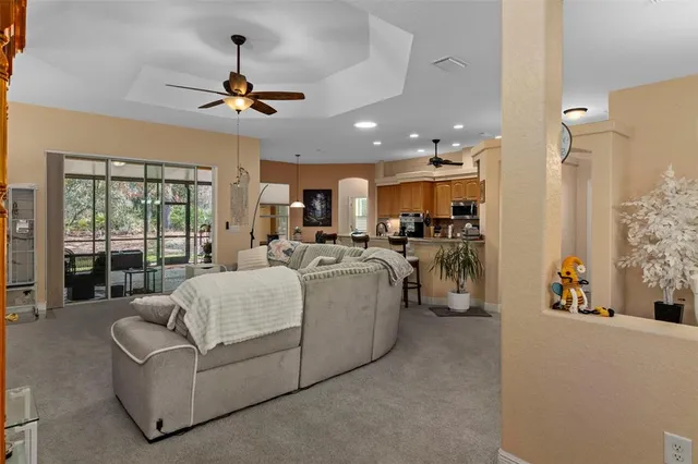 a living room with furniture kitchen view and a chandelier