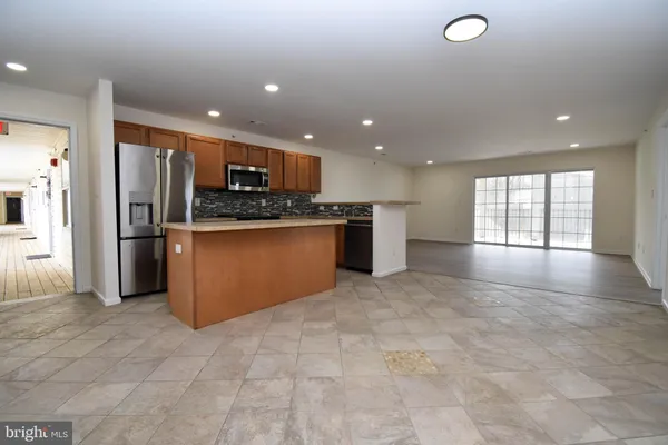 a kitchen with stainless steel appliances granite countertop a refrigerator a sink a stove and oven