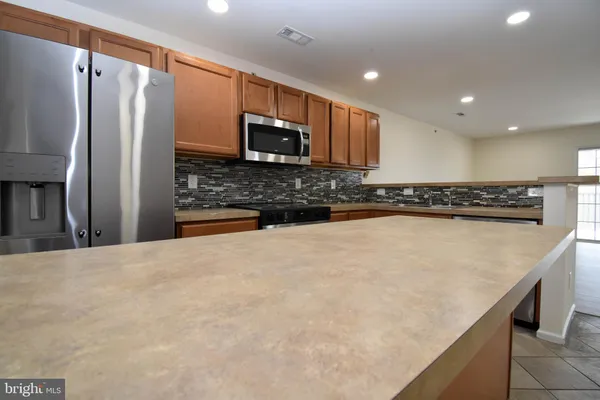a view of a kitchen with a sink and an empty room