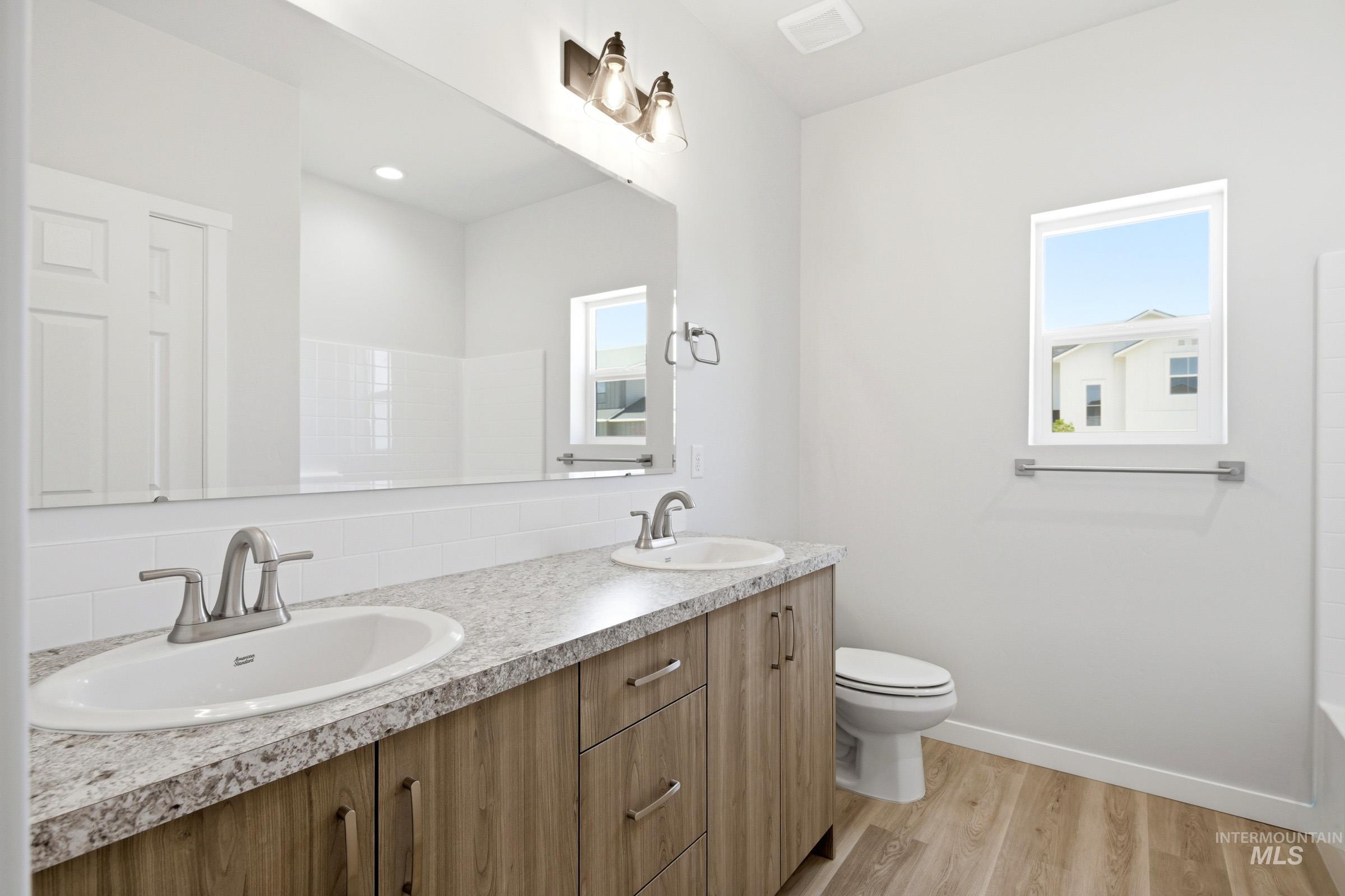 13649 Inman Court Caldwell, ID 83607 - Photo 18 of 22 Dual vanity with undermount sinks and brushed nickel faucets set in a speckled countertop