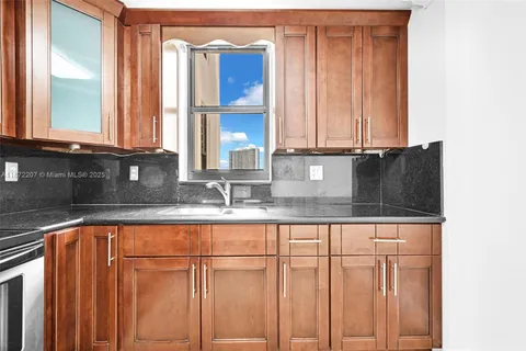 a kitchen with granite countertop white cabinets and sink