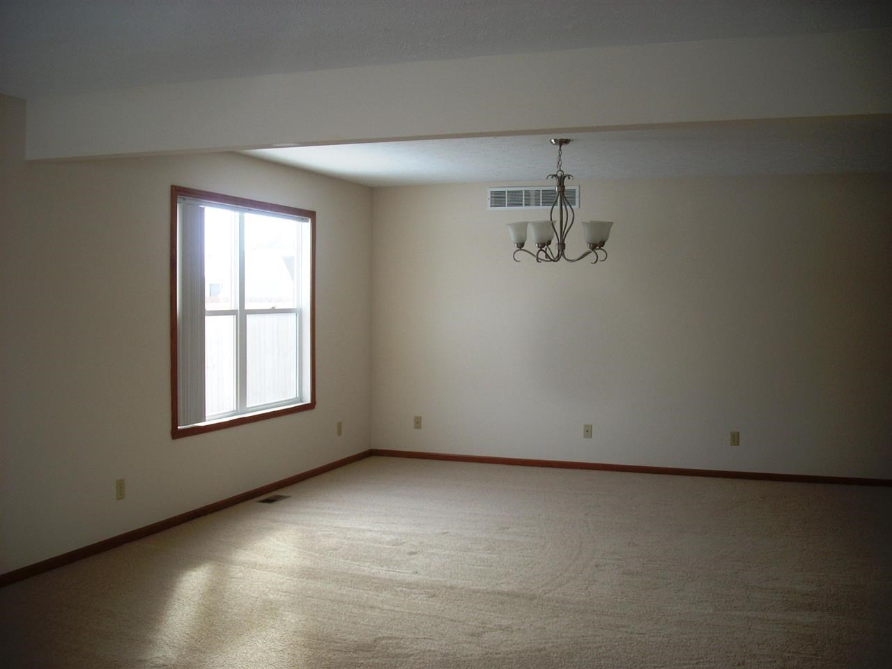 11090 Chicory Ridge Way Roscoe, IL 61073 - Photo 7 of 17 an empty room with chandelier fan and windows