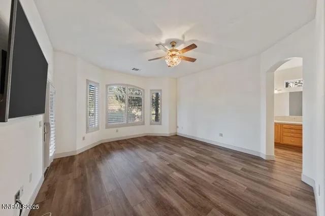 a view of an empty room with window and wooden floor