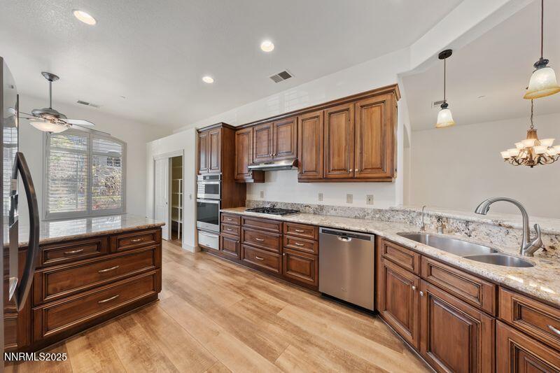 9900 Wilbur May Parkway, Unit 2501 Reno, NV 89521 - Photo 4 of 37 a kitchen with granite countertop wooden cabinets and stainless steel appliances