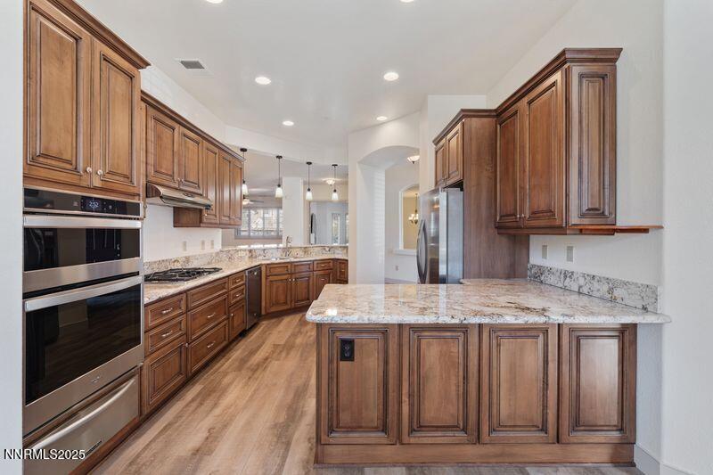 9900 Wilbur May Parkway, Unit 2501 Reno, NV 89521 - Photo 5 of 37 a kitchen with stainless steel appliances granite countertop a kitchen island wooden cabinets and granite counter tops