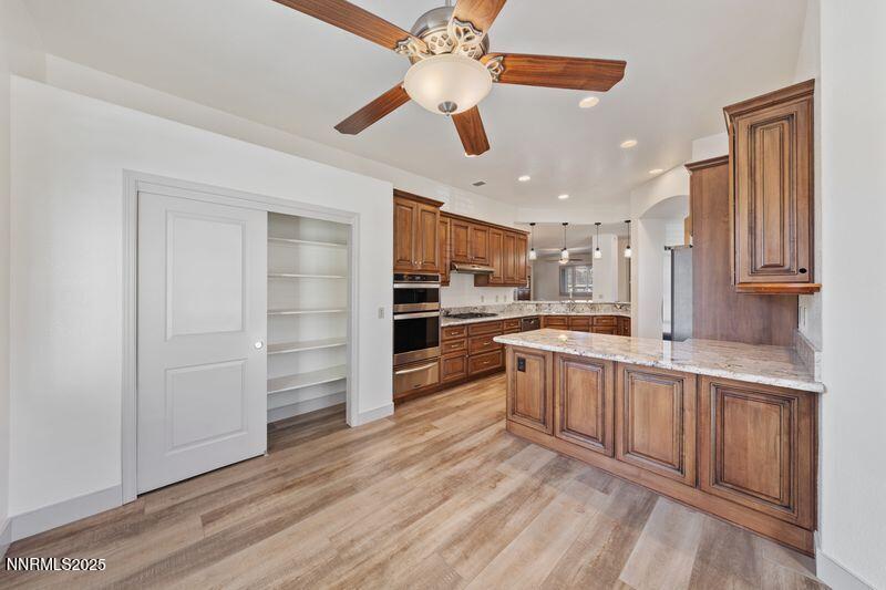 9900 Wilbur May Parkway, Unit 2501 Reno, NV 89521 - Photo 7 of 37 a large kitchen with stainless steel appliances kitchen island granite countertop a refrigerator and a stove top oven