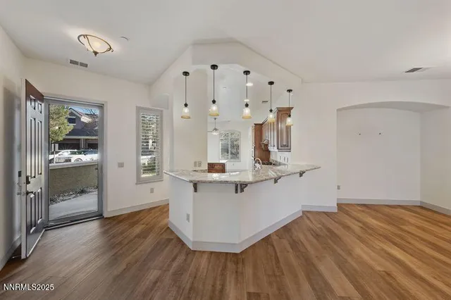 a view of a livingroom with wooden floor and a ceiling fan