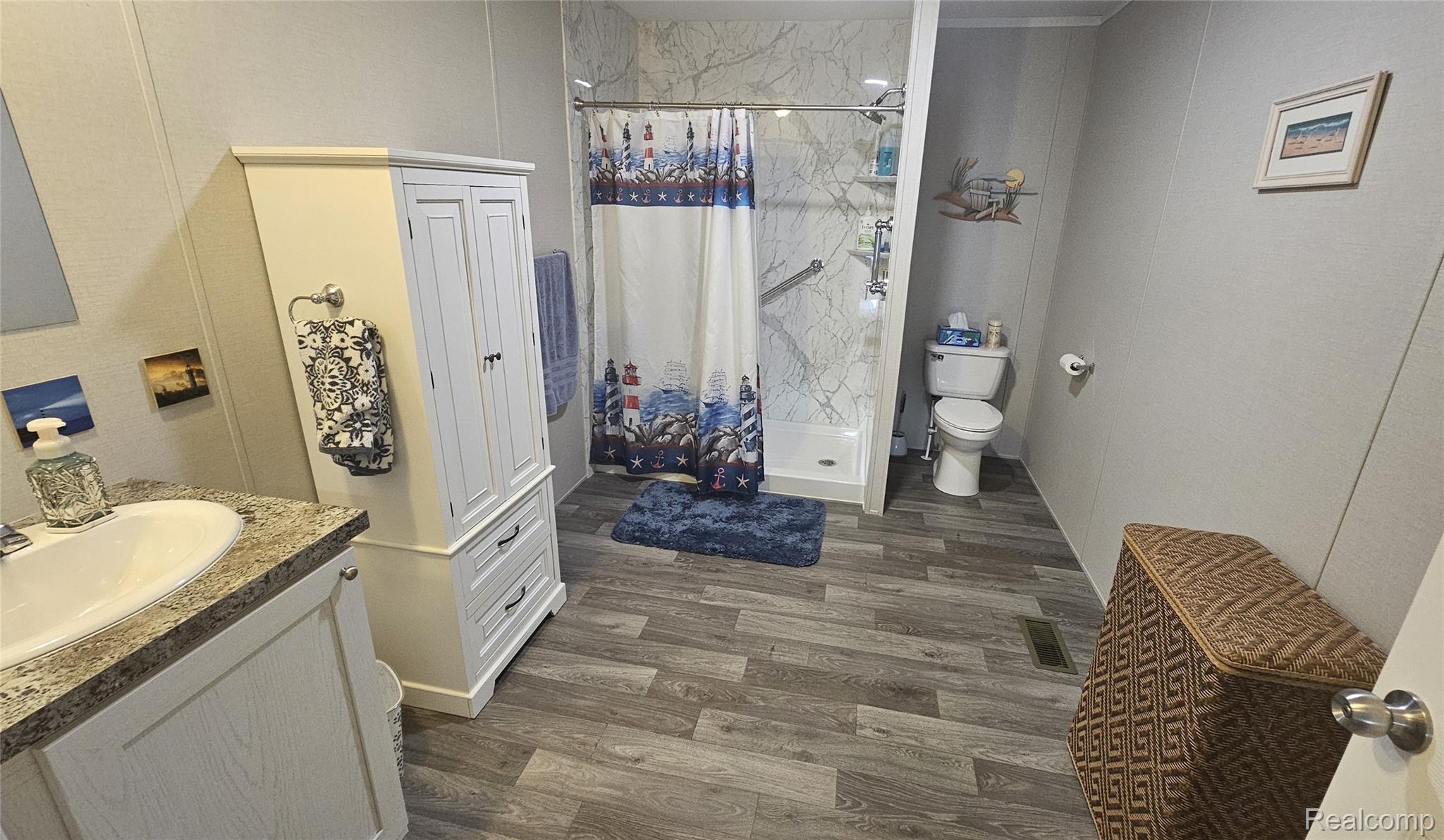 29 Hickory Ridge Davison, MI 48423 - Photo 12 of 26 Bathroom featuring a shower stall, vanity, and dark wood-style floors