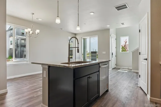 a view of a kitchen island a chandelier and wooden floor