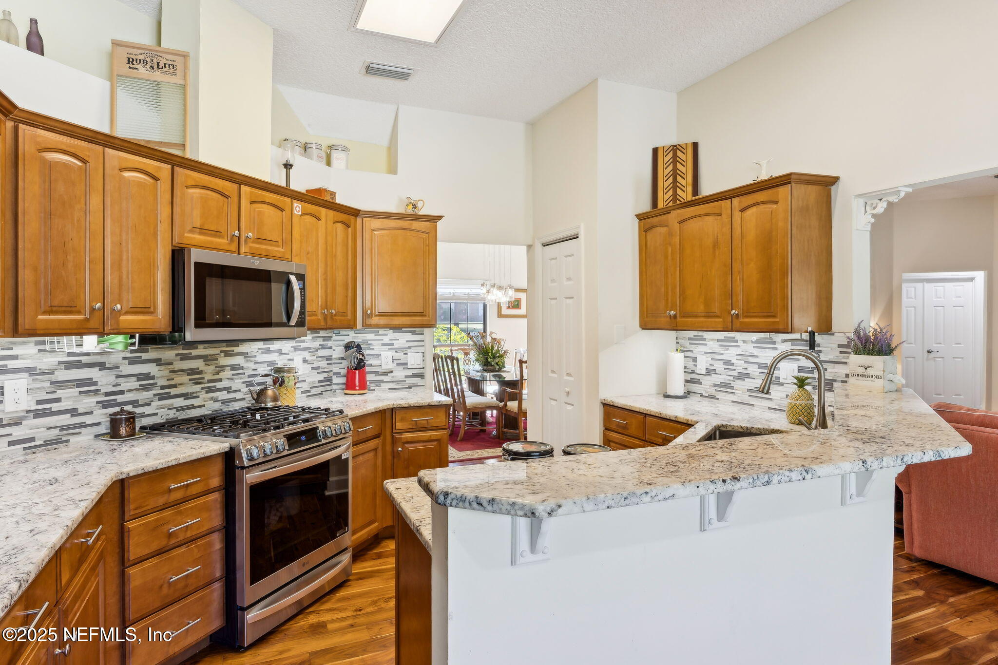6897 Miltondale Road Macclenny, FL 32063 - Photo 13 of 58 a kitchen with stainless steel appliances granite countertop a sink stove and microwave