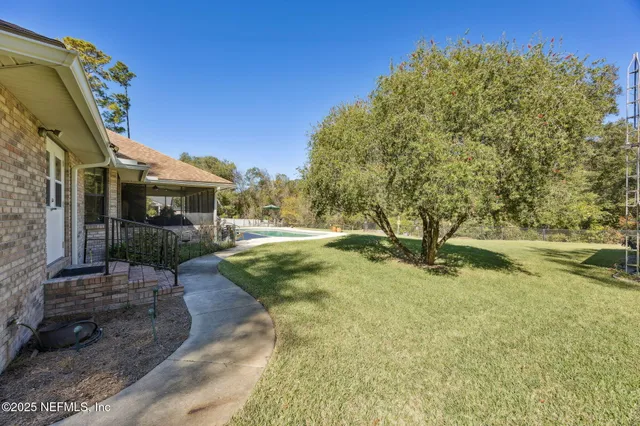 a view of a large house with a big yard and large trees