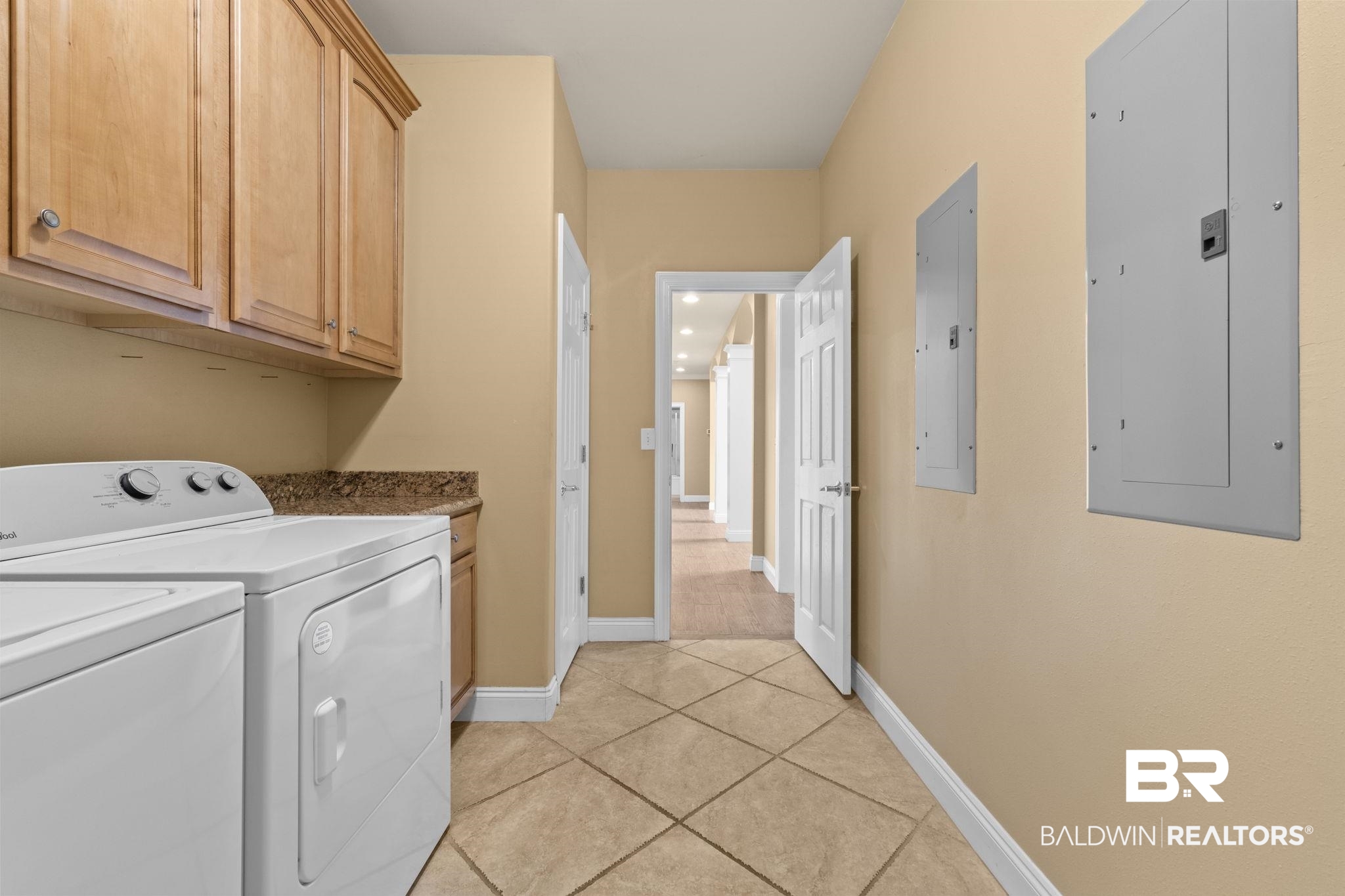9790 Stucki Road Elberta, AL 36530 - Photo 43 of 72 Laundry area with electric panel, cabinet space, light tile patterned flooring, and washer and dryer