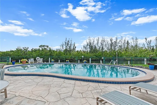 a view of a swimming pool and trees in the background