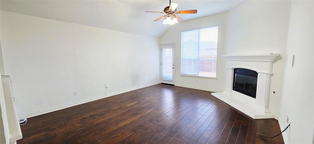 2697 Lake Ridge Drive Little Elm, TX 75068 - Photo 8 of 18 an empty room with wooden floor fan and windows