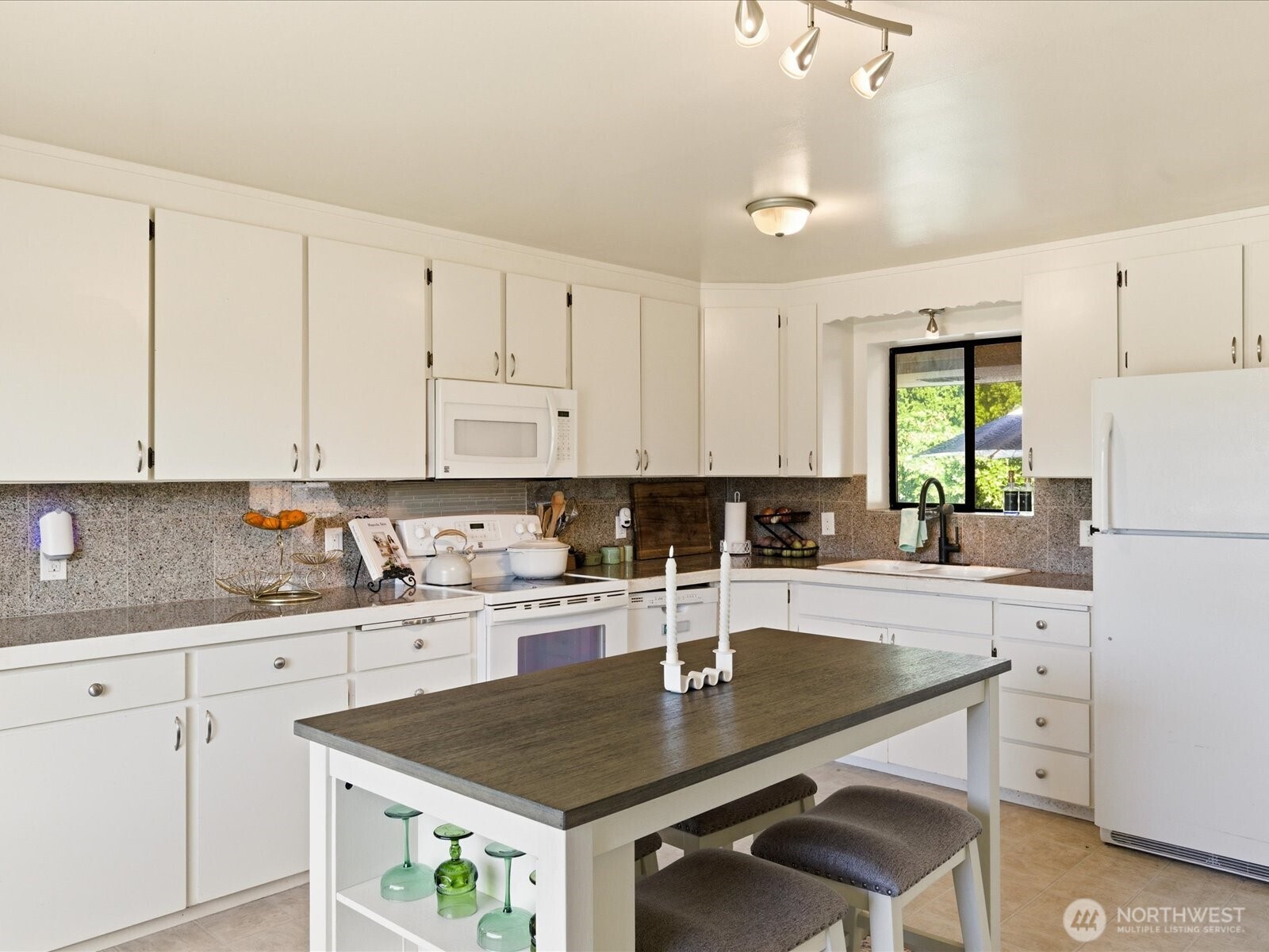 1417 Maple Street Sumner, WA 98390 - Photo 29 of 40 a kitchen with a sink a stove a refrigerator and white cabinets