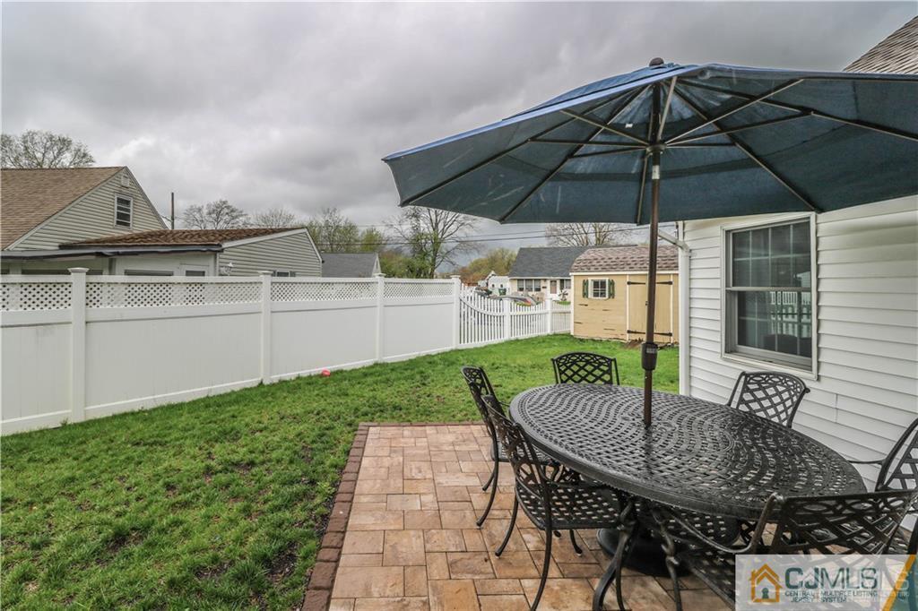 35 Stiles Road Edison, NJ 08817 - Photo 24 of 25 a patio with a table and chairs under an umbrella