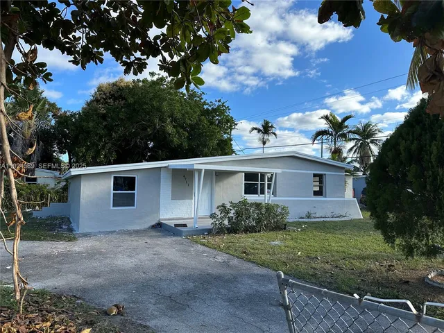 a front view of house with yard and trees around