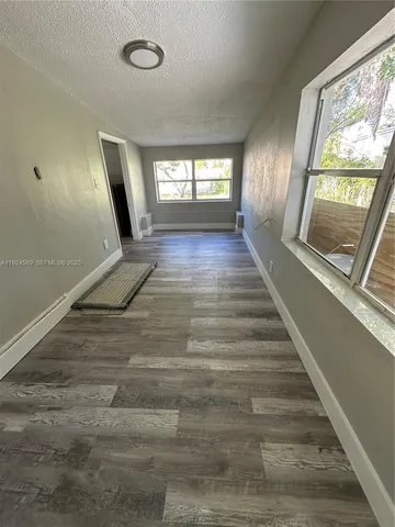 a view of entryway and hall with wooden floor