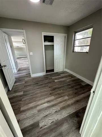 a view of a livingroom with wooden floor and stairs