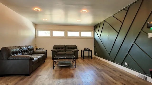 a living room with furniture and a wooden floor
