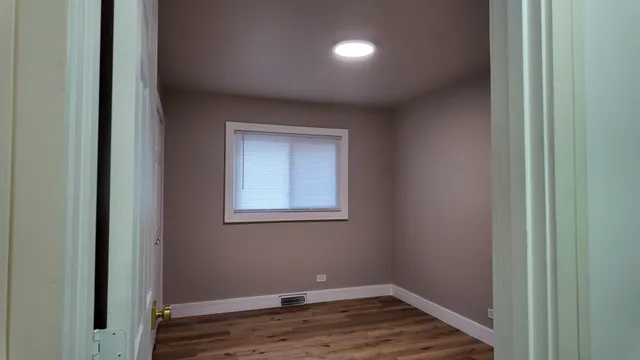 a view of a room with wooden floor and cabinet