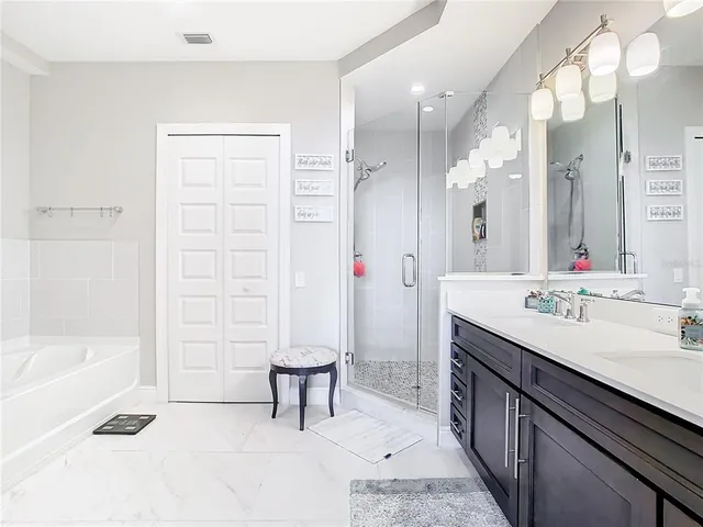 a spacious bathroom with a shower sink and a mirror