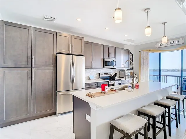 a kitchen with refrigerator and white cabinets
