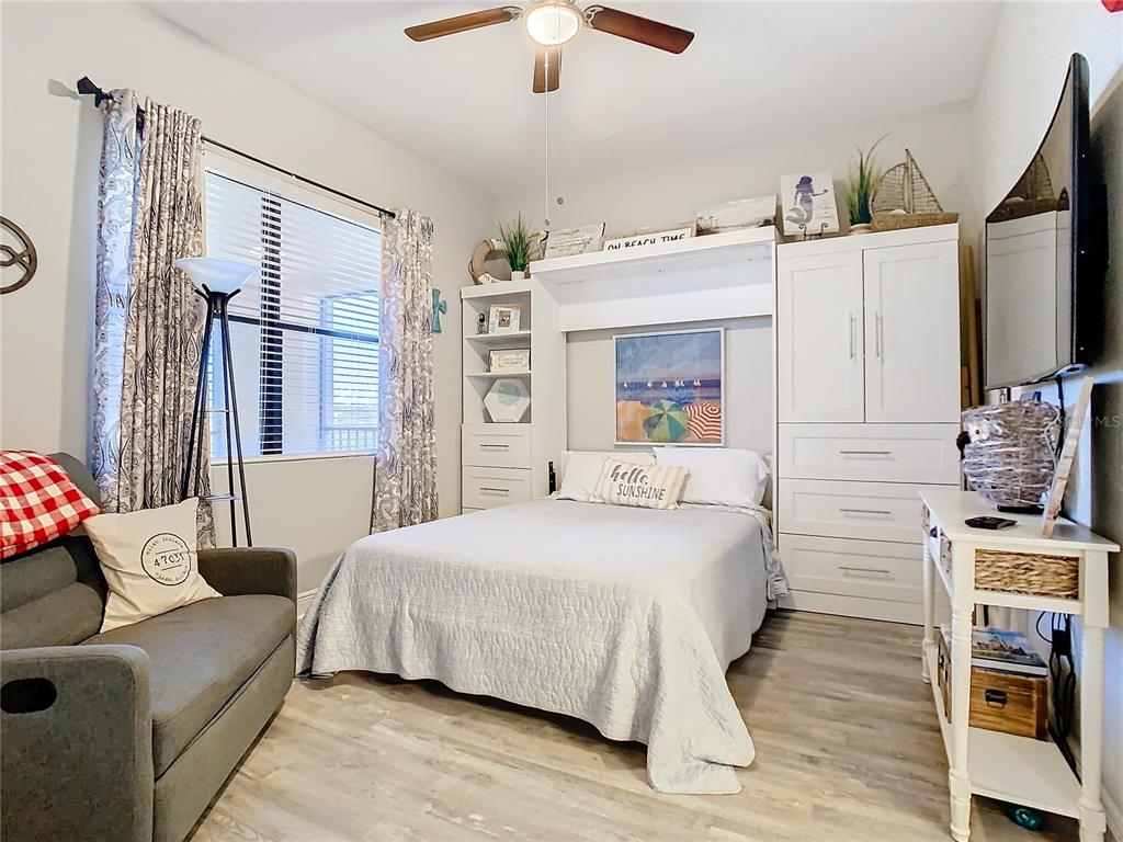 16300 County Road 455, Unit 610 Montverde, FL 34756 - Photo 8 of 22 a bedroom with a bed wooden floor and flat screen tv