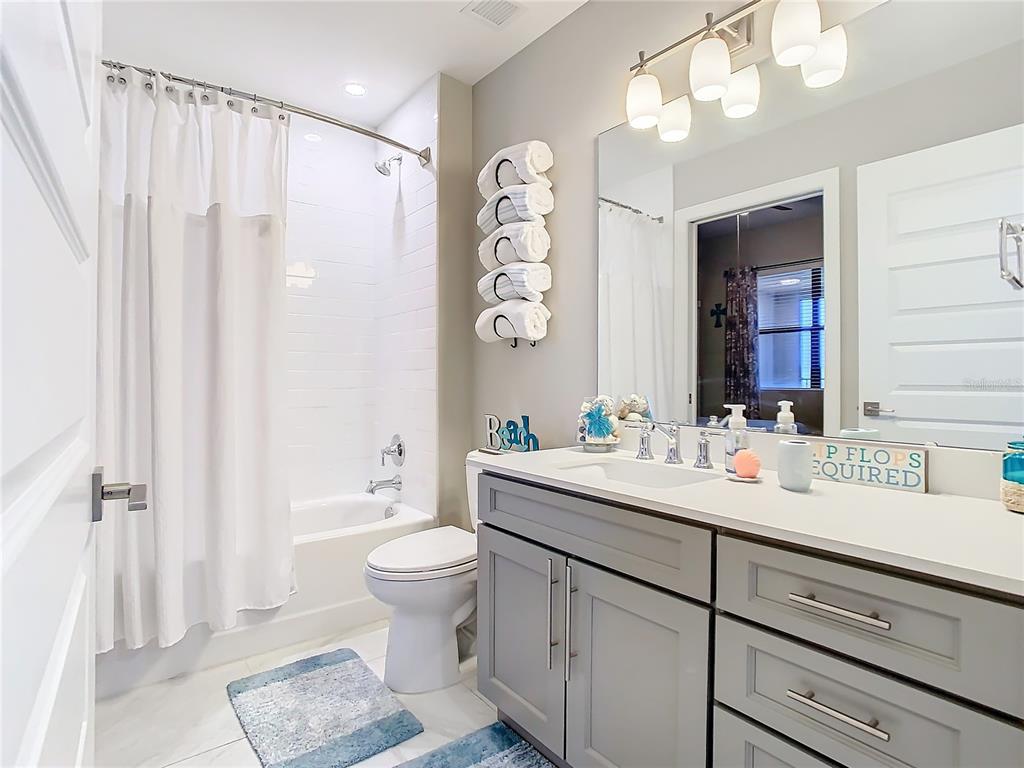 16300 County Road 455, Unit 610 Montverde, FL 34756 - Photo 9 of 22 a bathroom with a sink a toilet and a large mirror