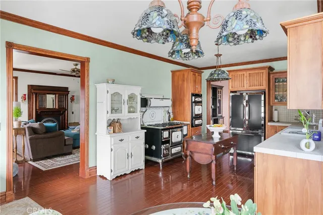a dining room with wooden floor a chandelier a glass table and chairs