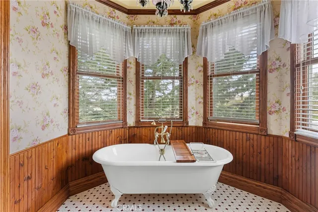 a bedroom with a bed a dresser and windows