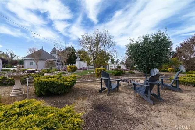 a front view of multiple house with yard green space and lake view in back