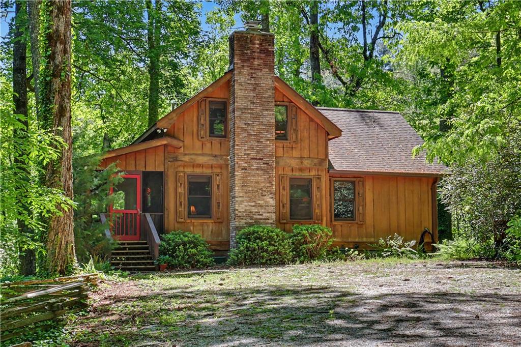 102 Moses Road Rabun Gap, GA 30568 - Photo 2 of 40 a front view of house with yard and trees in the background