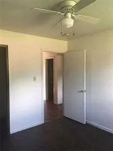 an empty room with wooden floor and a hallway