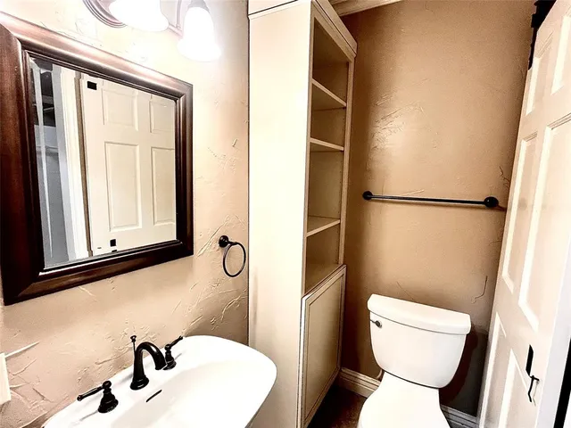 a bathroom with a toilet sink and a mirror