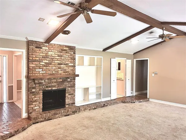 a view of an empty room with a fireplace and a window