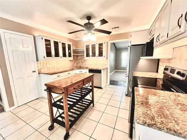 a living room with chairs a stove a dining table and chairs with wooden floor