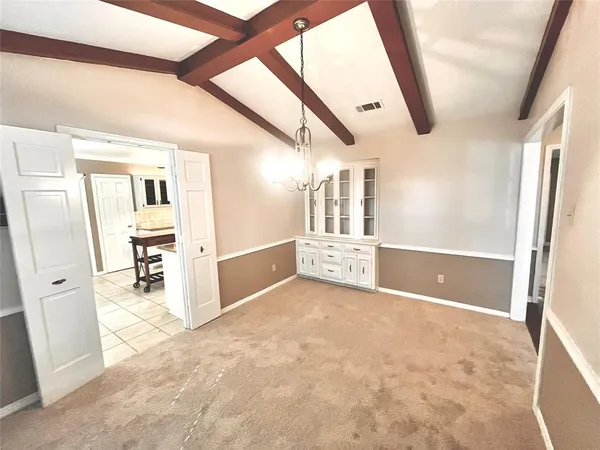 a view of a hallway with wooden cabinet and a kitchen view